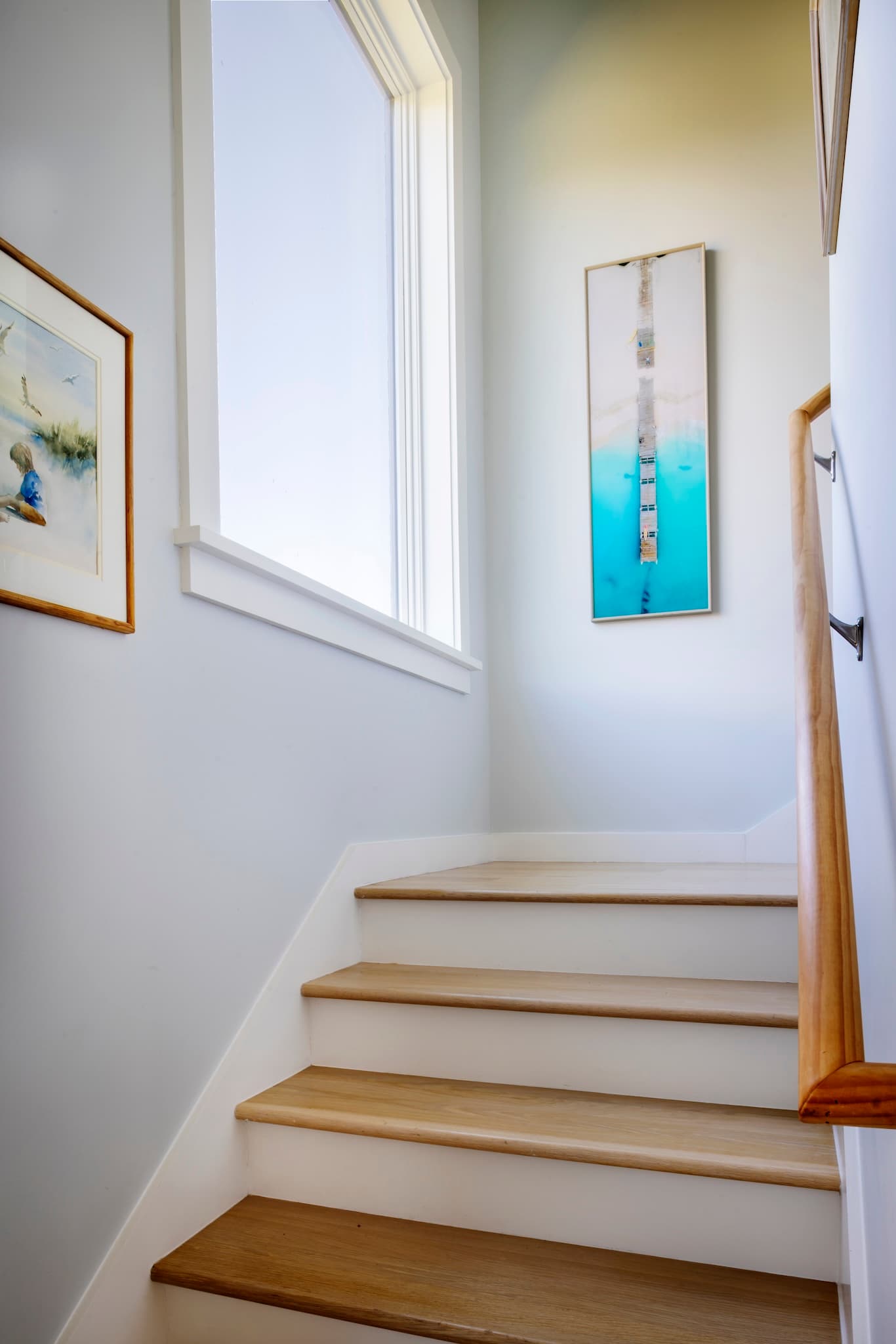 Stairwell with artwork lit by a large window