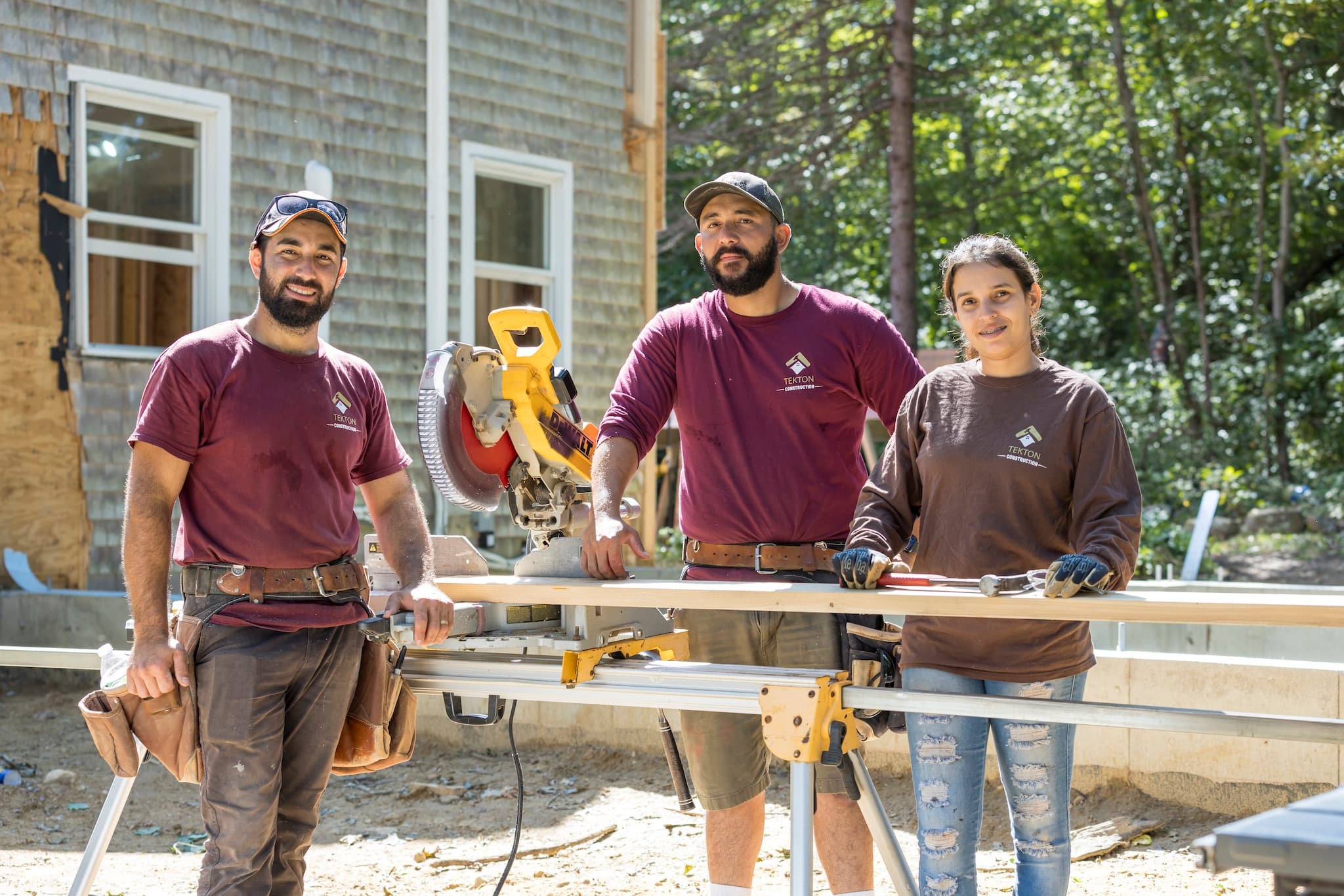 Tekton staff with a chop saw, hammer, and tools